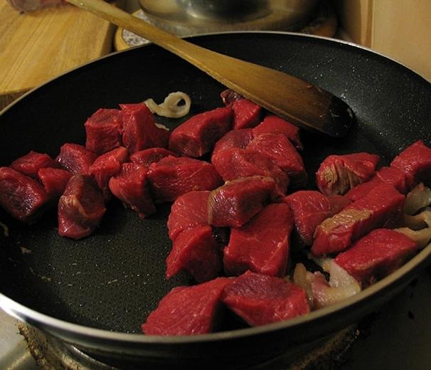 frite a carne com fatias em uma frigideira